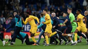 Les joueurs du FC Barcelone fuient les supporters de l'Espanyol après la victoire dans le derby (4-2).