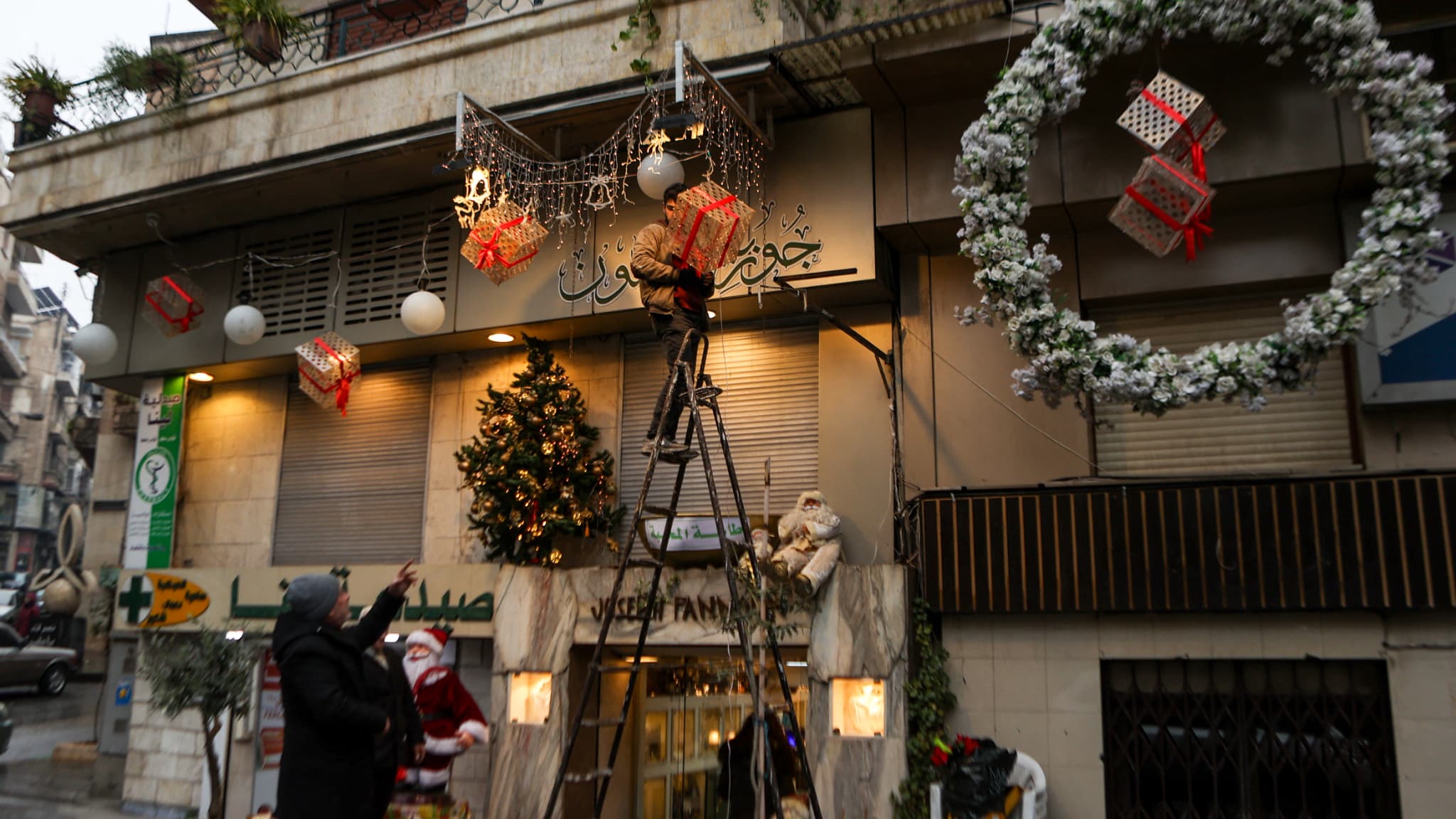 Des Syriens installent des décorations de Noël à Alep, le 23 décembre 2024. 