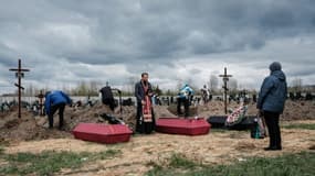 Nadia (D) assiste à l'inhumation de son époux et de deux autres personnes tuées, le 18 avril 2022 dans un cimetière de Boutcha, en Ukraine