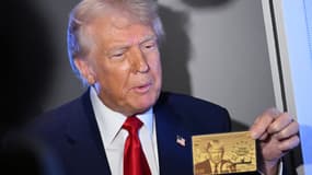 Le président américain Donald Trump tient la Gold Card, d'une valeur de 5 millions de dollars, alors qu'il s'adresse aux journalistes à bord d'Air Force One, en route pour Miami (Floride), le 3 avril 2025. 