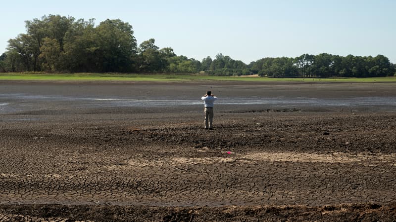 Un homme prend une photo du réservoir asséché de Canelon Grande au nord de Canelones, dans le sud de l'Uruguay, le 14 mars 2023.