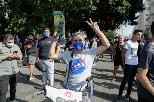 Un homme masqué tient un pistolet jouet au milieu d'affrontements entre des manifestants et des partisans des mouvements chiites libanais Hezbollah et Amal dans le centre de Beyrouth le 6 juin 2020 Un homme masqué tient un pistolet jouet au milieu d'affrontements entre des manifestants et des partisans des mouvements chiites libanais Hezbollah et Amal dans le centre de Beyrouth le 6 juin 2020