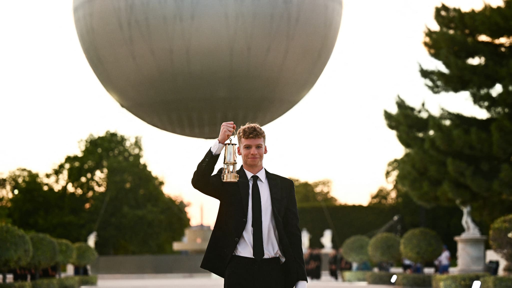 Léon Marchand avec la lanterne contenant la flamme olympique, cérémonie d'ouverture des JO de Paris 2024, 11 août 2024