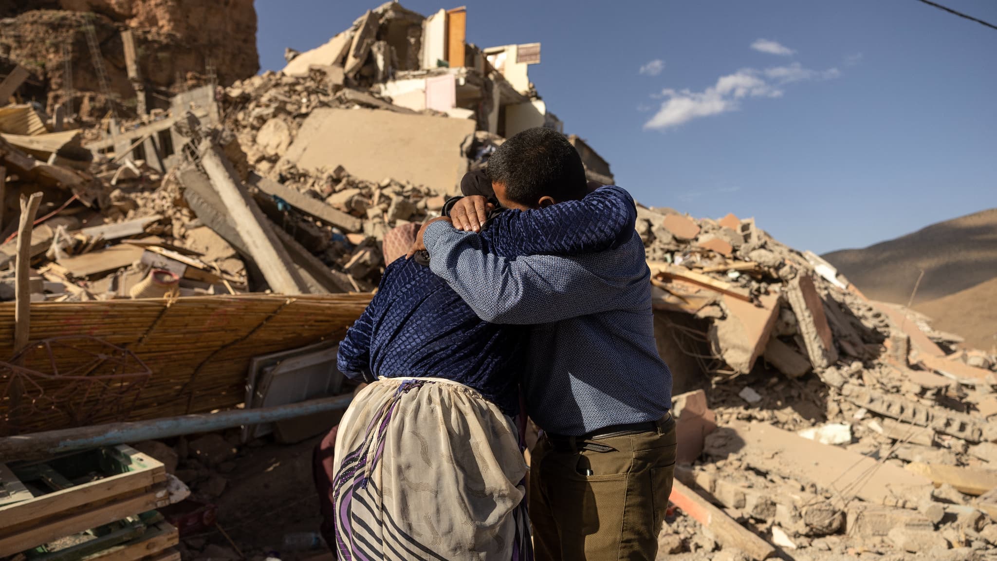Des membres d'une famille près des décombres de bâtiments effondrés dans le village d'Imi N'Tala près d'Amizmiz, au Maroc, après le séisme meurtrier de magnitude, le 10 septembre 2023.