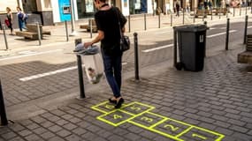 Un pochoir de marelle sur le trottoir guide la personne à une poubelle, à Lille, le 31 juillet 2018