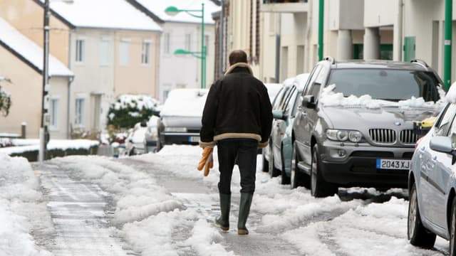 Un habitant marche dans une rue enneigée de Cherbourg (Manche) le 27 novembre 2010