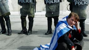 Devant la parlement grec, à Athènes. Le gouvernement grec a sommé samedi les députés frondeurs d'apporter leur soutien aux mesures d'austérité exigées par l'UE et le FMI pour la mise en oeuvre d'un second plan de sauvetage, faute de quoi ils engageront le