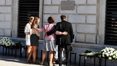 Les proches des victimes se recueillent devant la plaque commémorative dévoilée lundi.