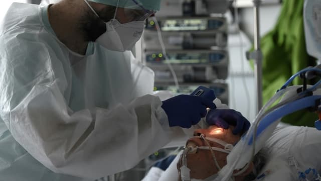 Un médecin s'occupe d'un patient atteint du coronavirus dans l'unité de soins intensifs de l'hôpital universitaire de Strasbourg, le 22 octobre 2020
