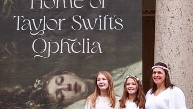Des fans de Taylor Swift déguisées en Ophelia devant au musée de Wiesbaden, devant une bannière portant la mention "Maison de l'Ophelia de Taylor Swift"