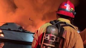 Un pompier tente d'éteindre un incendie dans un bateau au large de la côte californienne