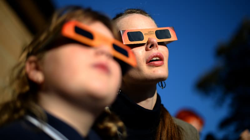 Personnes regardant une éclipse après avoir chaussé des lunettes de protection spéciales. (Illustration)