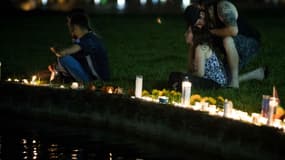 Des anonymes rendent hommage dans un parc d'Orlando le 12 juin 2016 aux victimes de la fusillade qui a eu lieu dans une boîte de nuit