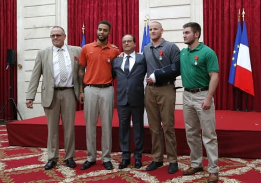 Le Président Francois Hollande pose entouré du britannique Chris Norman, et des Américains Anthony Sadler, Spencer Stone et Alek Skarlatos le 24 août 2015 à l'Elysée.