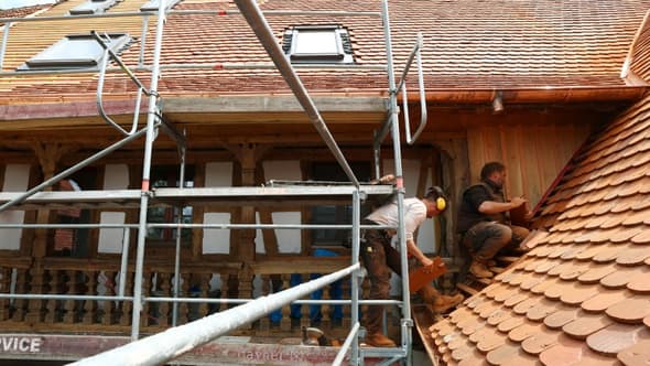 Des ouvriers travaillent à la rénovation d'une maison alsacienne typique à Uttwiller (Bas-Rhin) le 22 mai 2024