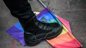 Un policier anti-émeute turc marche sur un drapeau arc-en-ciel lors d'un rassemblement organisé par la communauté LGBTQI+ sur l'avenue Istiklal à Istanbul le 19 juin 2016.