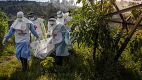 Des membres de la Croix-Rouge congolaise transportent des sacs mortuaires contenant des restes humains lors d'un enterrement de masse pour les victimes des affrontements dans l'est de la République démocratique du Congo au cimetière de Musigiko, à Bukavu, le 20 février 2025. 