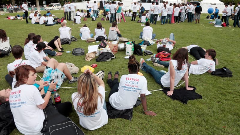 Des jeunes volontaires du service civique discutent sur la pelouse du Champs-de-mars