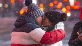 Un couple s'embrasse sous la neige sur Times Square, à New York, le 31 janvier 2021 (Photo d'illustration)