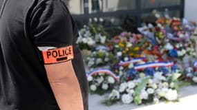 Un policier se recueille le 9 mai 2021 devant le commissariat de police d'Avignon, après la mort de son collègue Eric Masson tué le 5 mai