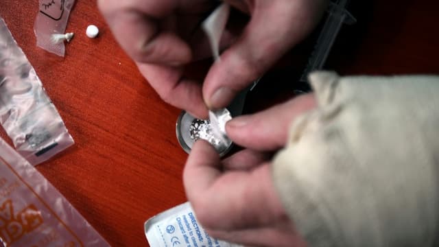 Un usager se prepare sa dose de cocaïne dans une camionnette transformée en salle de shoot à Glasgow, le 11 septembre 2020