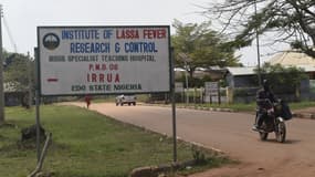 Un motocycliste passe devant un panneau de signalisation indiquant l'Institut de recherche et de contrôle de la fièvre de Lassa à l'hôpital universitaire spécialisé d'Irrua, à Irrua, dans l'État d'Edo, dans le Midwest du Nigeria, le 6 mars 2018.