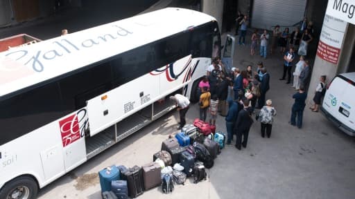 Un bus de réfugiés haïtiens, qui fuient les Etats-Unis pour demander l'asile au Canada, arrive au stade olympique de Montréal, le 3 août 2017