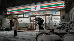 Des clients sortent d'une supérette à Kyoto alors qu'une forte tempête de neige frappe l'ancienne cité impériale. Cet événement météorologique extrême risque fort de perturber fortement la vie quotidienne de milliers de personnes dans les prochains jours. 
