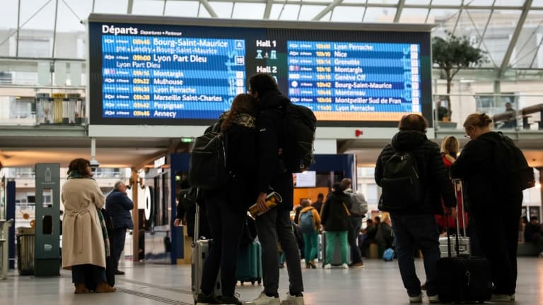 Des passagers regardent le panneau de départ à la Gare de Lyon, à Paris, le 16 février 2024.