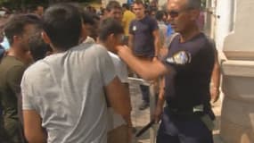 Un policier débordé par l'afflux de migrants au commissariat de l'île de Kos, lundi 10 août.