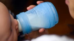 Une mère donne le biberon à son bébé. (Illustration)