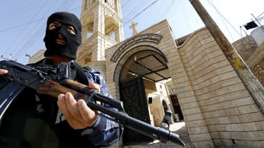 Un officier irakien garde une église catholique aux environs de Bartala, près de Mossoul, le 15 juin.