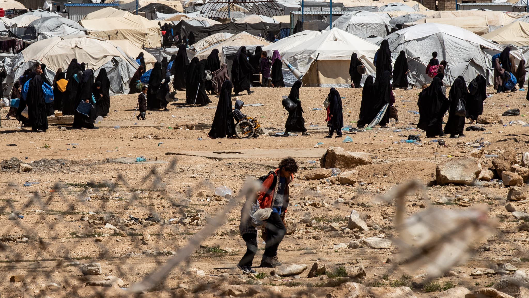 Des personnes marchent dans le camp d'Al-Hol,, dans le nord-est de la Syrie, le 18 avril 2025, alors que les Forces démocratiques syriennes mènent une campagne de sécurité contre les "cellules dormantes" de Daesh dans le camp. Des personnes marchent dans le camp d'Al-Hol,, dans le nord-est de la Syrie, le 18 avril 2025, alors que les Forces démocratiques syriennes mènent une campagne de sécurité contre les "cellules dormantes" de Daesh dans le camp.