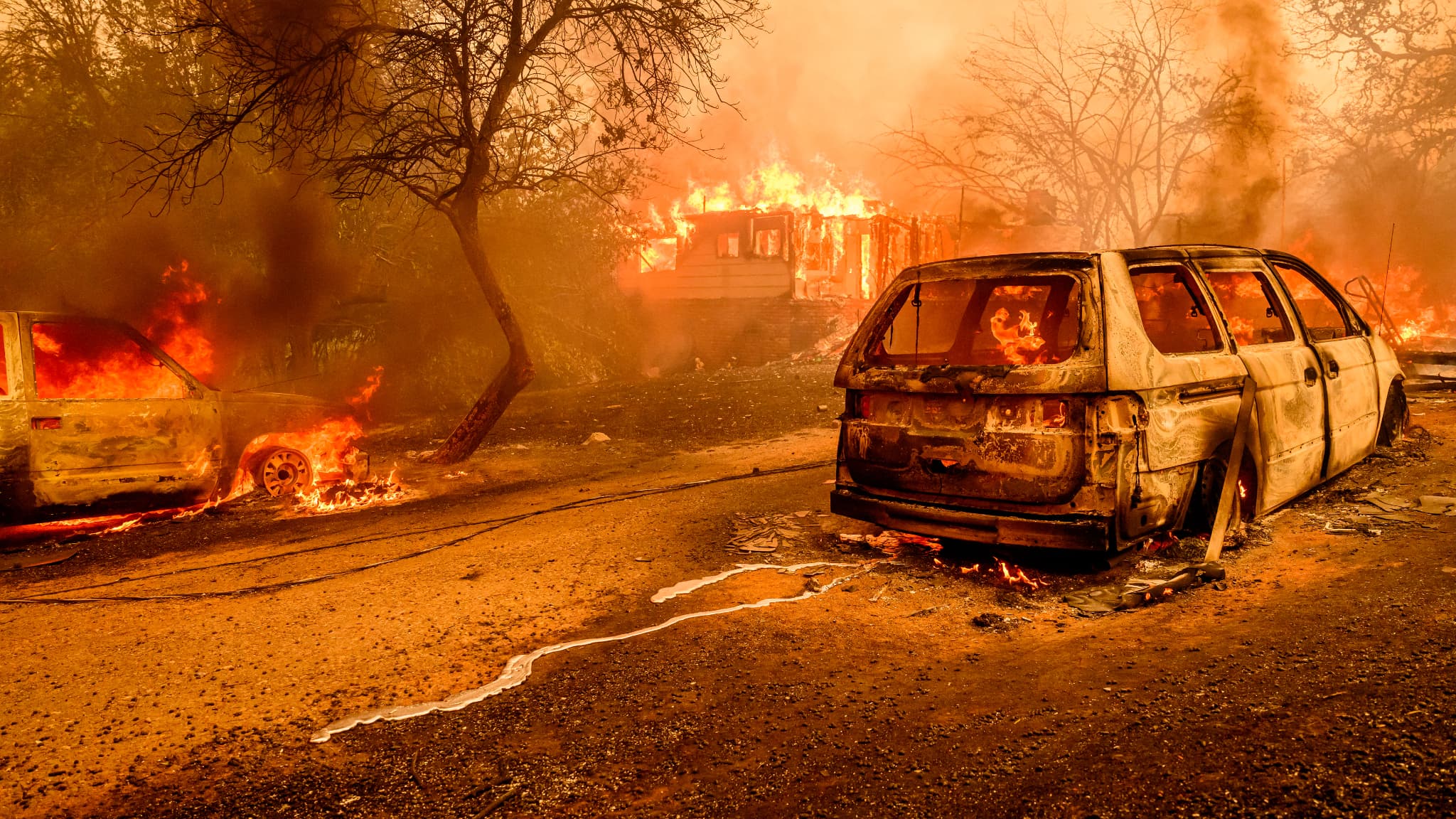 Des voitures brûlées alors les flammes engloutissent une maison à Oroville, en Californie, aux États-Unis, le 2 juillet 2024.