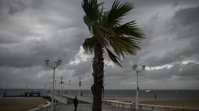 Un homme marche sur le front de mer avant la tempête Ciaran le 1er novembre 2023, à Arcachon, dans le sud-ouest de la France.