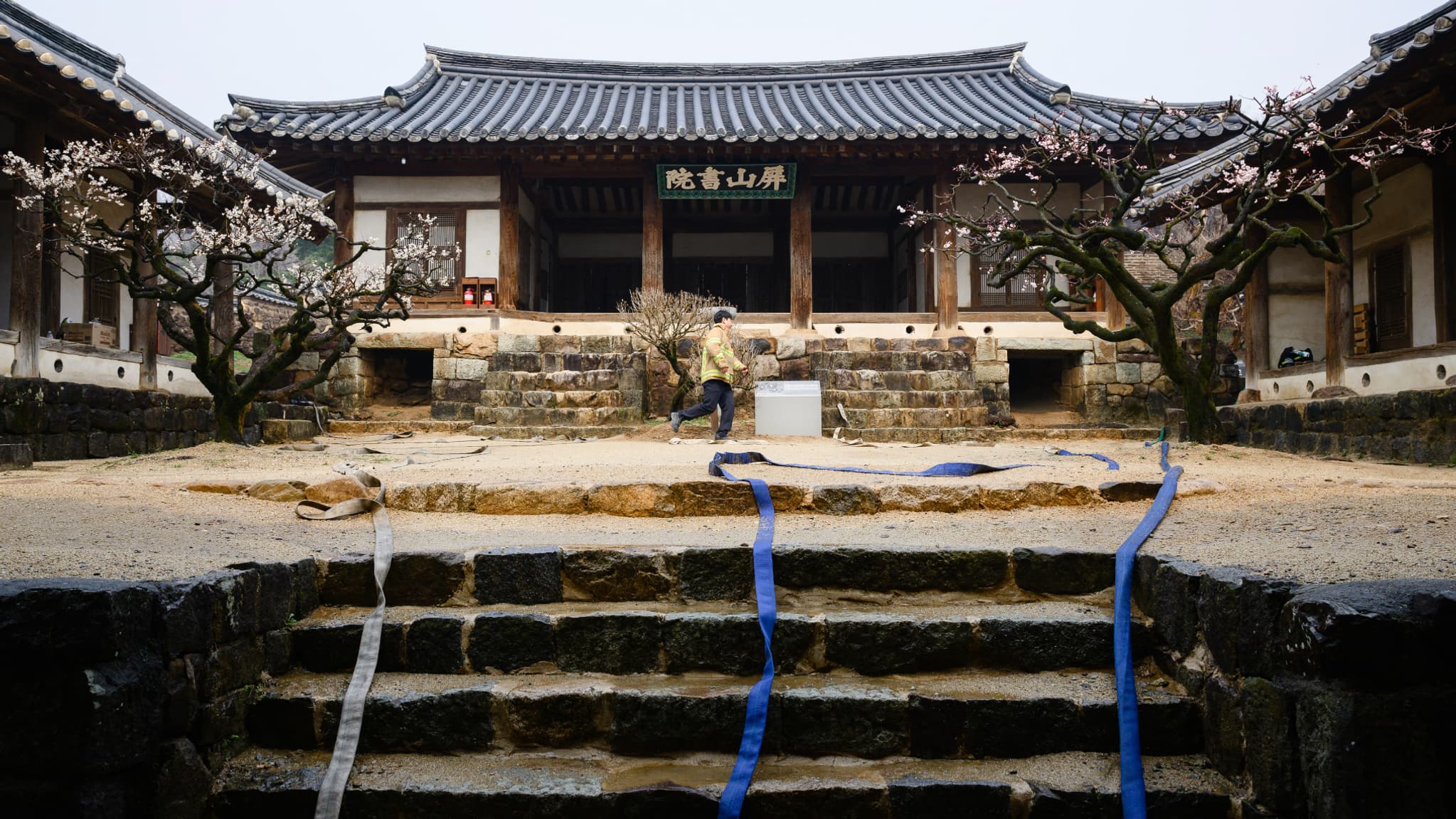 Un pompier passe devant des lances à incendie sur les marches menant au site de Byeongsan Seowon, une ancienne académie confucéenne classée par l'UNESCO, à Andong (Corée du Sud), le 27 mars 2025. Un pompier passe devant des lances à incendie sur les marches menant au site de Byeongsan Seowon, une ancienne académie confucéenne classée par l'UNESCO, à Andong (Corée du Sud), le 27 mars 2025.