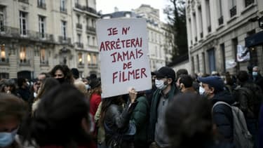 Un manifestant porte une pancarte "Je n'arrêterai jamais de filmer" lors d'un rassemblement contre la proposition de loi sur la "sécurité globale" à l'appel des syndicats de journalistes et de diverses organisations, à Paris le 17 novembre 2020
