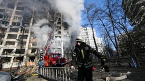 Des pompiers devant un immeuble en flammes après un bombardement, à Kiev le 15 mars 2022