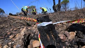 Des membres de la cellule départementale de Recherche des causes et circonstances des incendies de forêts (RCCI 30) enquêtent sur le site d'un incendie, le 3 août 2022 à Générac, dans le Gard 