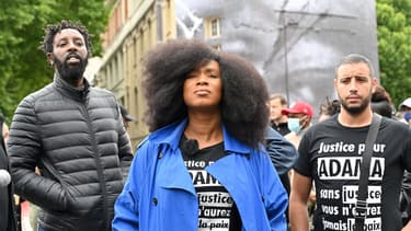 La soeur d'Adama Traoré accompagnée du réalisateur Ladj Ly pose devant un collage de JR en hommage à son frère à Paris, le 9 juin 2020