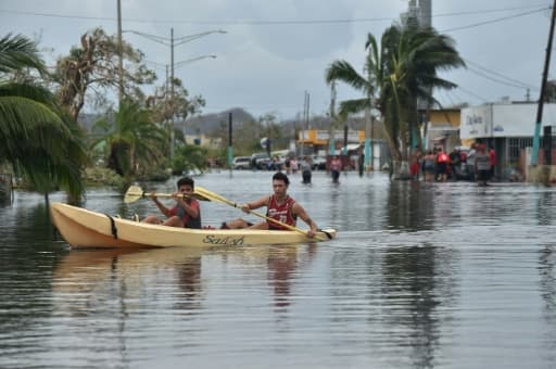 Des habitants utilisent un kayak pour se déplacer dans leur rue inondée, à Juana Matos, sur lîle de Porto Rico, le 21 septembre 2017 après le passage de l'ouragan Maria Des habitants utilisent un kayak pour se déplacer dans leur rue inondée, à Juana Matos, sur lîle de Porto Rico, le 21 septembre 2017 après le passage de l'ouragan Maria