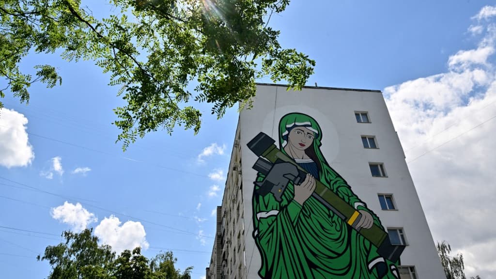 Cette photo montre une peinture murale créée par le groupe créatif Kailas-V, représentant une Madone symbolique tenant un missile antichar, inspirée du projet "Saint-Javelin", à Kiev, le 14 juin 2022, en pleine invasion de l'Ukraine par la Russie. Cette photo montre une peinture murale créée par le groupe créatif Kailas-V, représentant une Madone symbolique tenant un missile antichar, inspirée du projet "Saint-Javelin", à Kiev, le 14 juin 2022, en pleine invasion de l'Ukraine par la Russie.