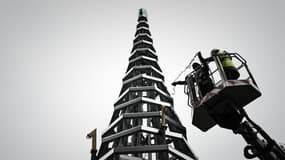 Des ouvriers participent à la construction d'un arbre de Noël de 11 mètres de haut entièrement en acier (recyclable) et en verre (recyclé) devant la cathédrale Saint-André à Bordeaux, dans le sud-ouest de la France, le 7 décembre 2021.