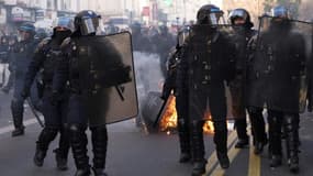 La police anti-émeutes intervient près d'un feu allumé par des manifestants lors d'un rassemblement à l'initiative de LFI notamment contre la réforme des retraites, à Paris le 21 janvier 2023