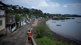 Un homme marche le long du port dans le quartier de Majicavo à Mamoudzou, sur l'île française de Mayotte dans l'océan Indien, le 19 février 2024.