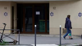 Une femme passe devant un immeuble où des étoiles de David ont été taguées dans la nuit, dans le quartier d'Alésia, à Paris, le 31 octobre 2023