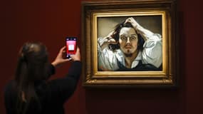 Un visiteur prend une photo avec son téléphone portable du tableau "Autoportrait", également connu sous les noms "Le Désespéré" (1843-1845) du peintre français Gustave Courbet, exposé en prêt au musée d'Orsay, à Paris, le 13 octobre 2025.
