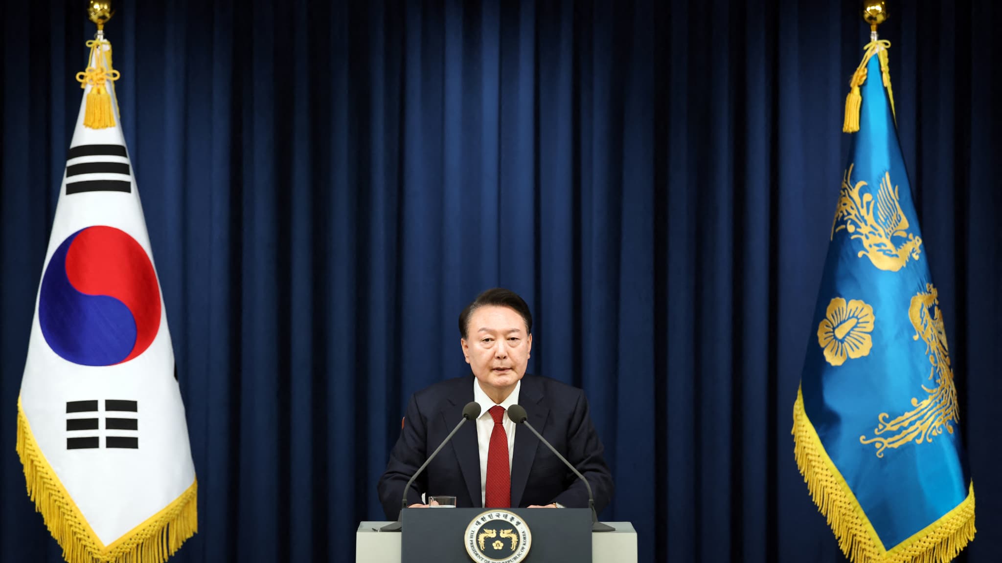 Ce document du bureau présidentiel sud-coréen, pris le 3 décembre 2024, montre le président sud-coréen Yoon Suk Yeol prononçant un discours pour déclarer la loi martiale à Séoul. Ce document du bureau présidentiel sud-coréen, pris le 3 décembre 2024, montre le président sud-coréen Yoon Suk Yeol prononçant un discours pour déclarer la loi martiale à Séoul.