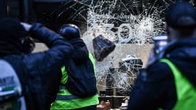Des manifestants brisent une vitrine, à Paris, le 1er décembre 2018.
