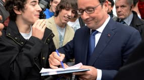 Hollande, en visite à Angoulême, signe le mot d'absence d'un lycéen, jeudi 9 octobre 2014.